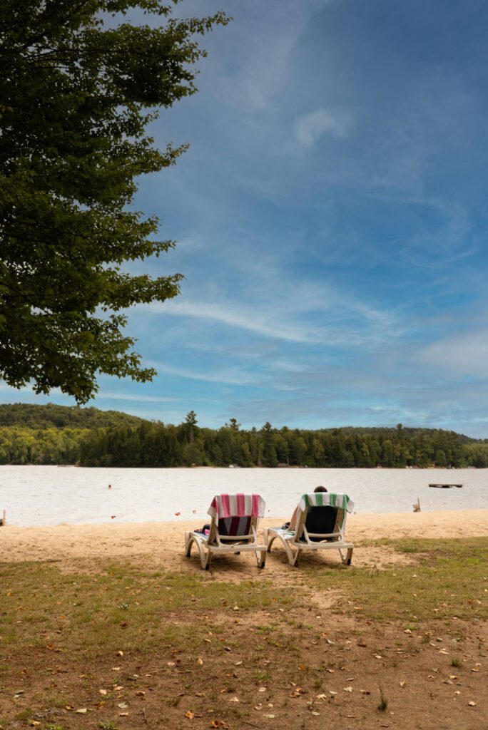 Two Muskoka chairs on a beach