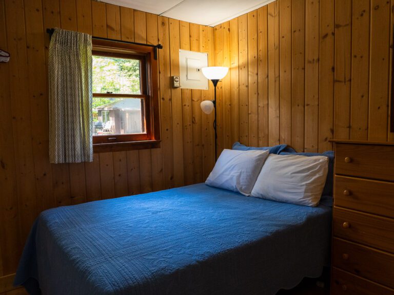 Bed in wood-panelled bedroom