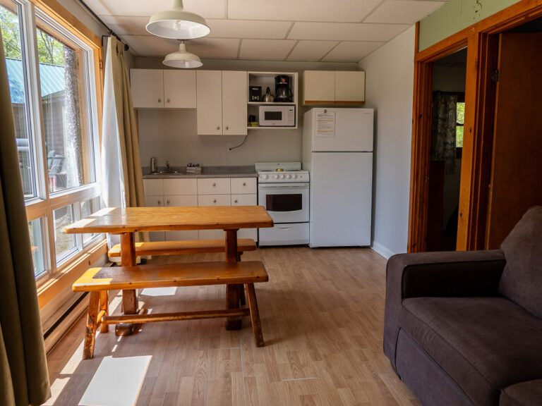 View of cottage kitchen with couch and table by window