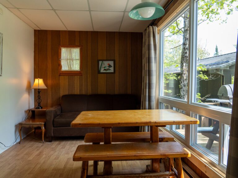 Wooden table by large window lookign out on greenery