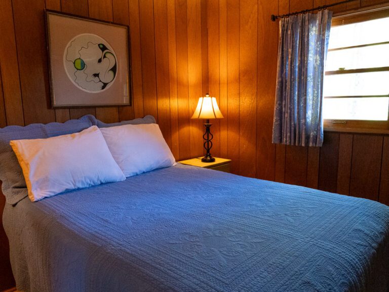 Bedroom with world map above the bed and glowing bedside lamp