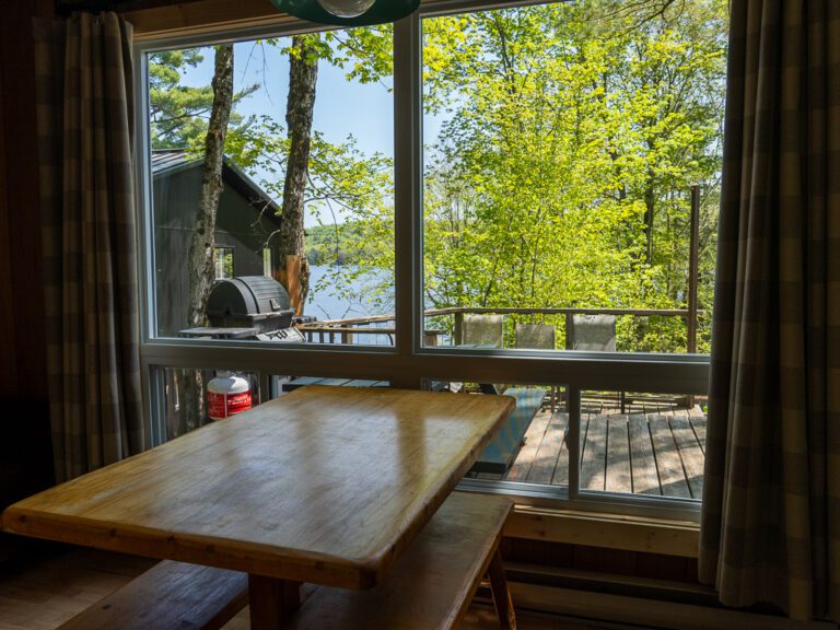 View across kitchen table in cottage looking out towards large window