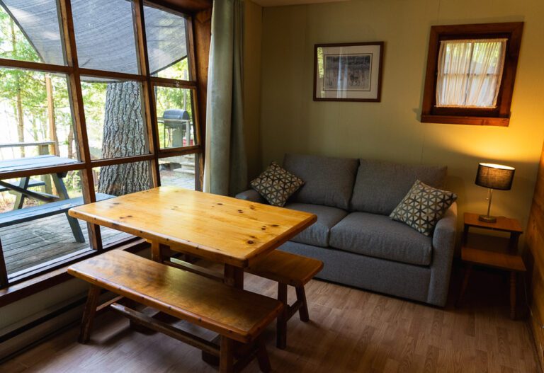 Couch, table, and wall of windows in a cottage