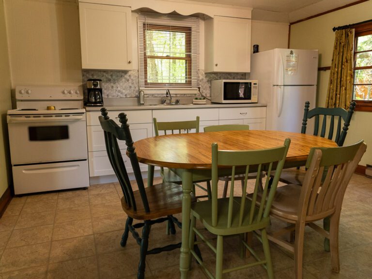 Cottage kitchen table, with sink and cupboards behind